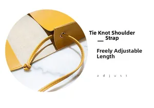 Detail of a bright yellow PU saddle bag showing the knotted adjustable shoulder strap