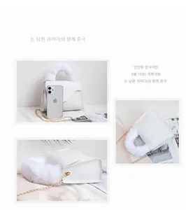 Detail of white square crossbody bag featuring fluffy faux fur handle and gold chain strap