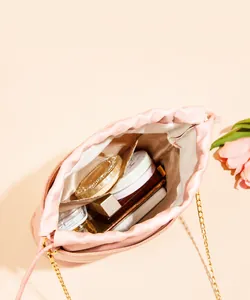 Interior view of small pink drawstring bucket bag showing storage for makeup essentials