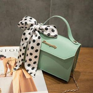 Mint green shoulder bag with golden chain and large polka dot bow ribbon detail