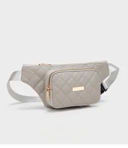 Detailed view of grey quilted waist bag with golden zippers and nylon shoulder strap