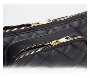 Detail of black quilted leather waist bag featuring premium dual gold metal zippers