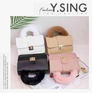 Detail of colorful plush handles and gold metal locks on textured faux leather bags