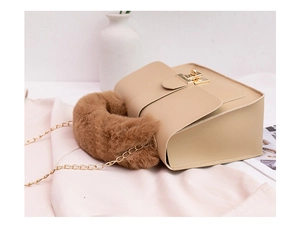 Detail of plush brown handle and golden clasp on beige small square crossbody bag