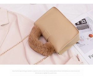 Detail of plush faux fur handle and premium full-grain leather on a stylish chain handbag