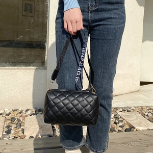 Black quilted cylinder crossbody bag with stylish letter print wide shoulder strap