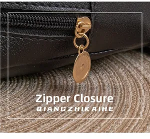 Detail of a smooth golden metal zipper closure on a black quilted faux leather bag