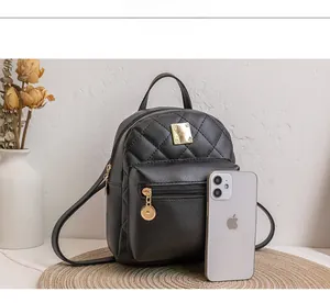 Size comparison of black quilted mini backpack next to a smartphone for scale