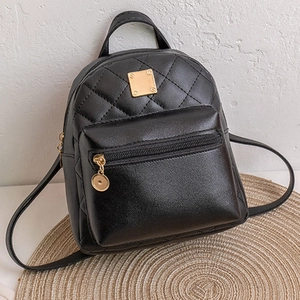 Détail du mini sac à dos en similicuir noir matelassé avec des ornements dorés chic