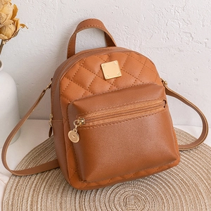 Détail d'un mini sac à dos en cuir matelassé marron avec finitions dorées élégantes