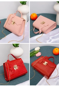 Close-up of pink and red crocodile pattern handbags with gold chain and metal buckle