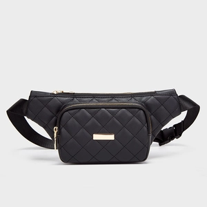 Quilted black fanny pack with gold zippers and adjustable strap on grey background