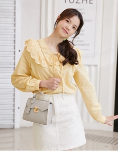 Close-up of grey crocodile pattern handbag with gold hardware and elegant chain strap
