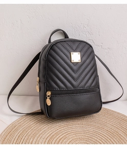 Detail of black V-quilted faux leather mini backpack with polished gold hardware zippers