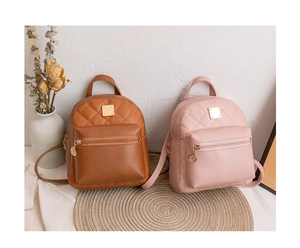 Detail of mini quilted backpacks in brown and pink with golden square metal accents