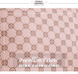 Close-up of pink synthetic leather material featuring brown clover and heart patterns