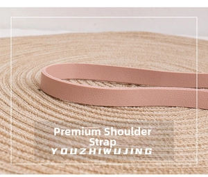 Detail shot of a pink leather shoulder strap featuring premium grain texture