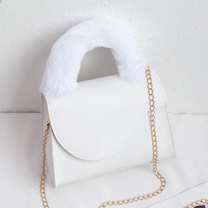 White minimalist saddle bag with fluffy faux fur handle and gold chain strap detail