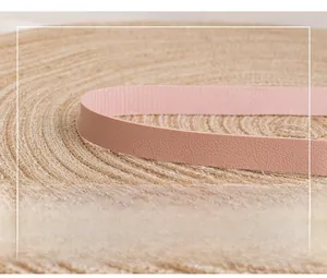 Macro detail of high-quality pink leather strap with lychee texture on woven mat