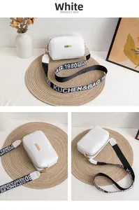 Detail of white PU leather crossbody bag with golden plate and woven logo strap
