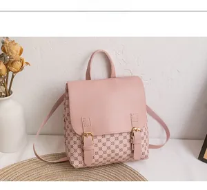 Detailed view of pink floral backpack with textured leather flap and golden buckles