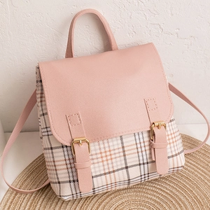 Detail of pink PU leather flap and beige plaid fabric on small stylish knapsack