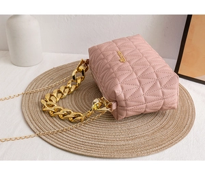 Detailed view of pink quilted crossbody bag with chunky gold chain handle and chain strap