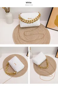 Close-up of white quilted crossbody bag with gold chunky chain handle and elegant embroidery