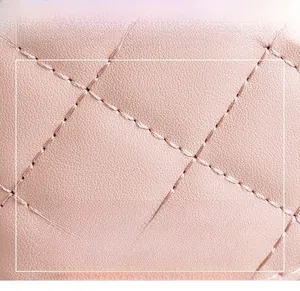 Macro shot of light pink quilted PU leather with uniform stitching and soft texture