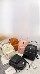 Quilted mini backpacks in brown, pink, beige, and black on a soft white plush rug