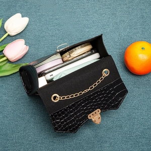 Black crocodile pattern crossbody bag with gold chain strap and daily essentials