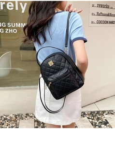 Detailed view of black quilted mini backpack with gold hardware and PU leather texture