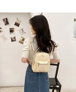 Detail of a beige quilted mini backpack featuring a gold zipper and Korean fashion style