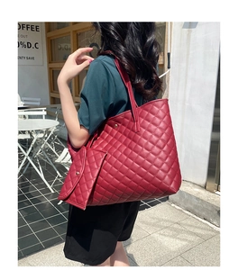 Detail shot of a wine red diamond quilted tote bag with matching pouch