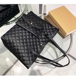 Detail of black quilted tote bag and matching coin purse on a glass table setup