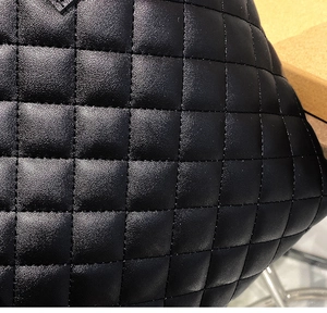 Macro shot of elegant black quilted leather texture and detailed stitching on the bucket bag