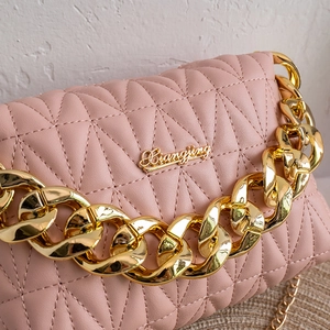 Pink quilted crossbody bag with gold chain strap and elegant rhombic pattern texture