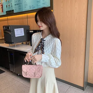 Pink quilted crossbody handbag with gold buckles shown in a stylish cafe setting
