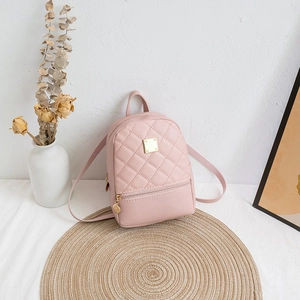 Chic light pink quilted mini backpack with gold hardware on a decorative mat