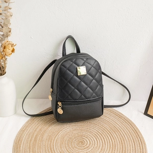 Fashionable black quilted mini backpack with gold hardware on a minimalist background