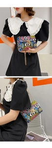 Close-up of snake print crossbody bag with colorful patterns and golden metal turn lock