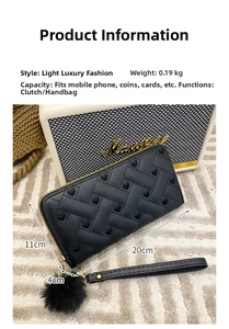 Detail view of black embroidered wallet with pompom charm and 20x11x4cm dimensions