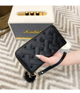 Close-up of black long wallet with heart embroidery, pompom charm, and wristlet strap