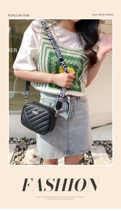 Detail of black quilted crossbody bag with stylish wide letter-printed shoulder strap