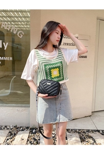 Detail of black quilted crossbody bag with a wide patterned shoulder strap