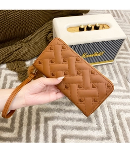 Brown leather wallet featuring quilted heart patterns and a wrist strap detail