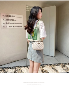 Detail of a beige quilted crossbody camera bag with elegant gold metal twist lock