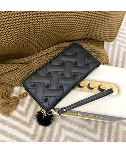 Detail of black woven wallet with heart embroidery, plush pompom and gold zipper
