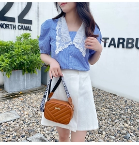 Brown quilted crossbody bag with stylish black and white lettered webbing strap detail