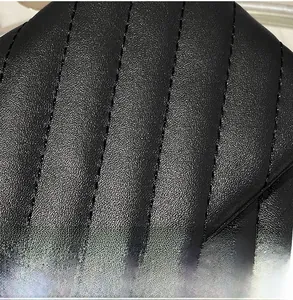 Macro detail of high-quality black quilted faux leather with vertical stitching